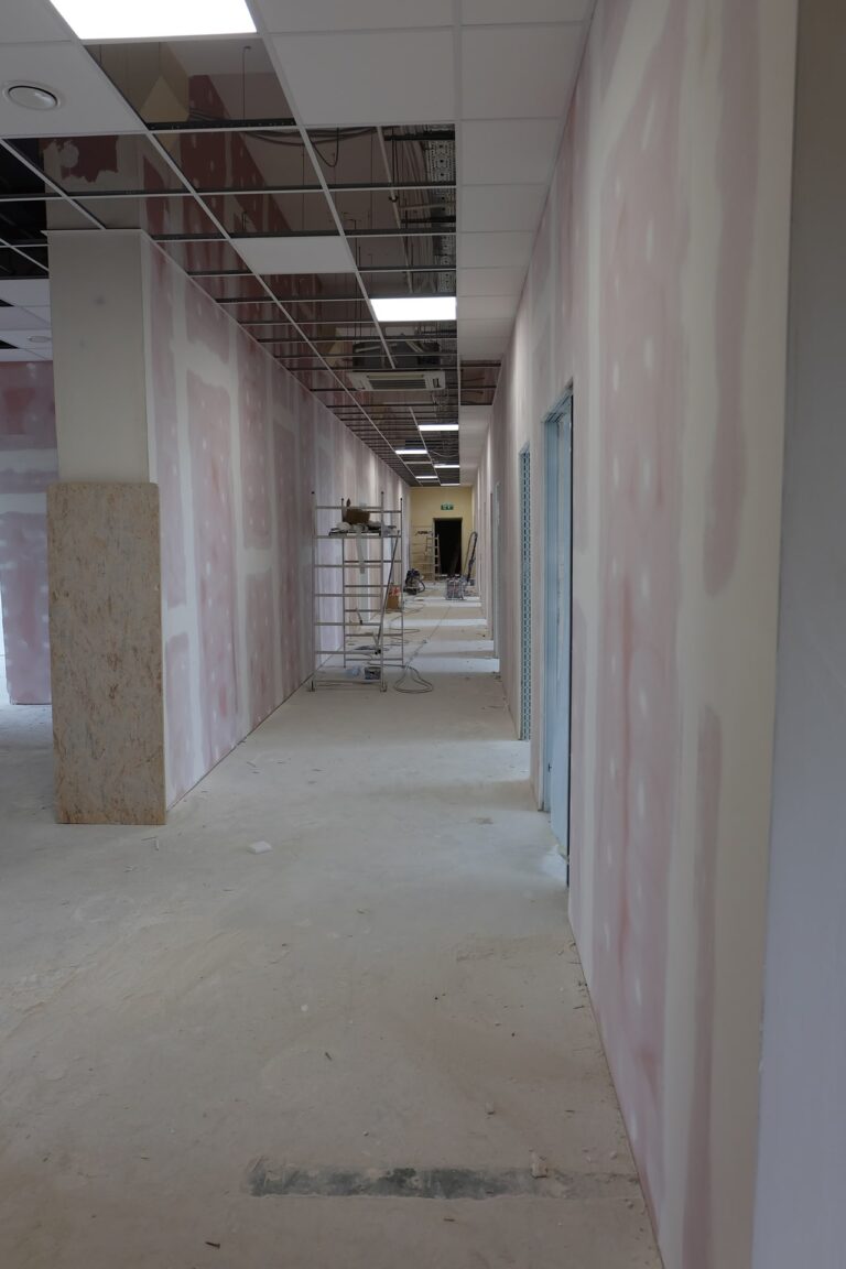 Na zdjęciu widać korytarz w czasie remontu. ściany są w gładzi