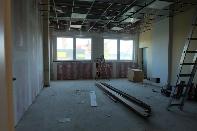 na zdjęciu widać pokój w czasie remontu są nim duże okna i 2 drabiny na podłodze są belki i wielka skrzynia